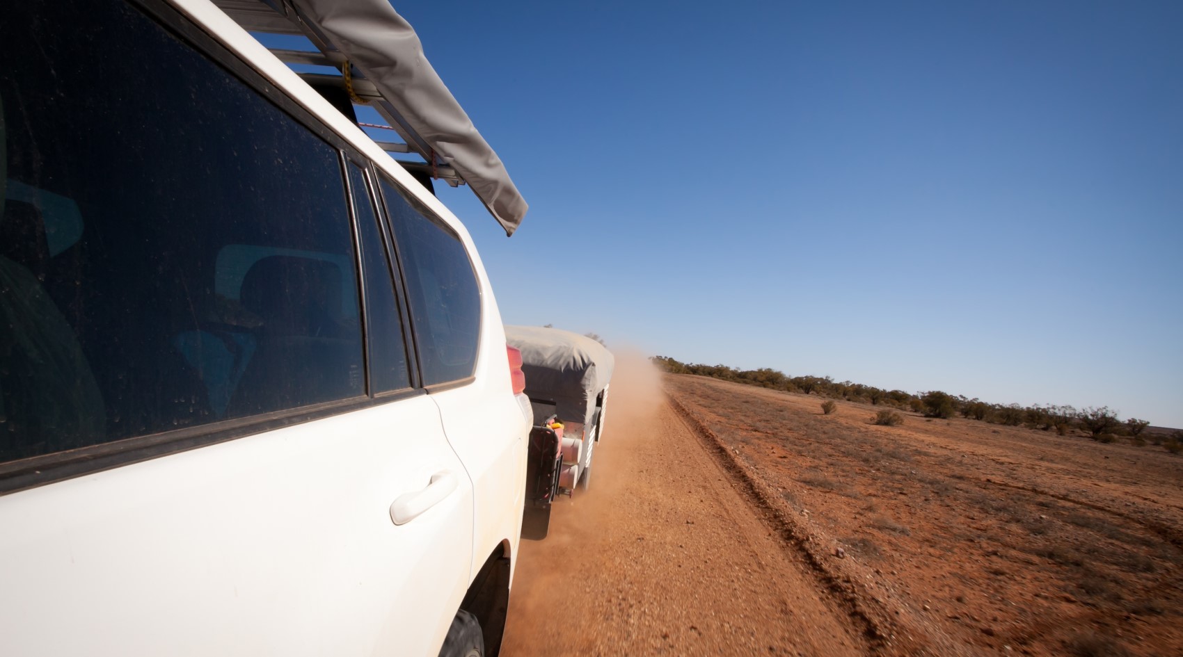 4WD towing a camper trailer on dirt road