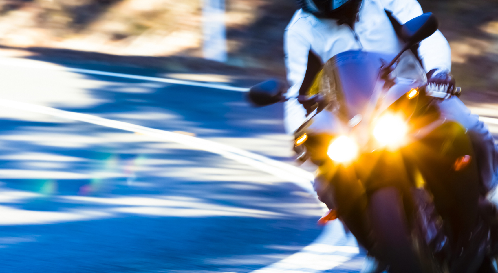 A motorcyclist with their lights on.