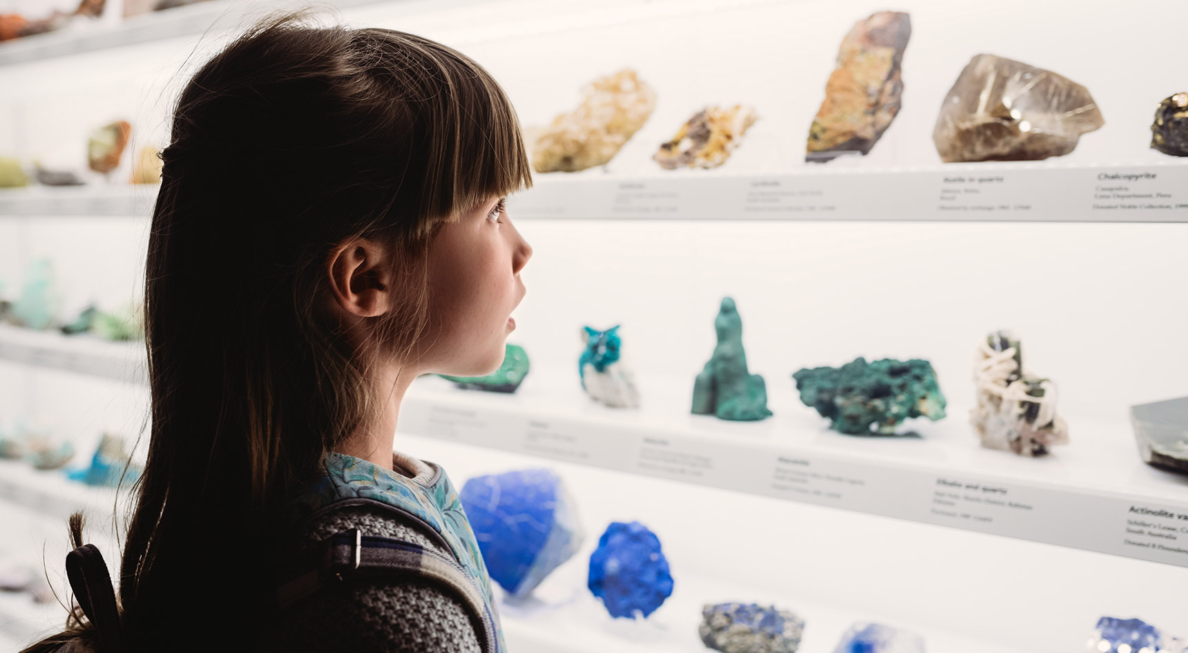 Young girl looking at colourful rocks