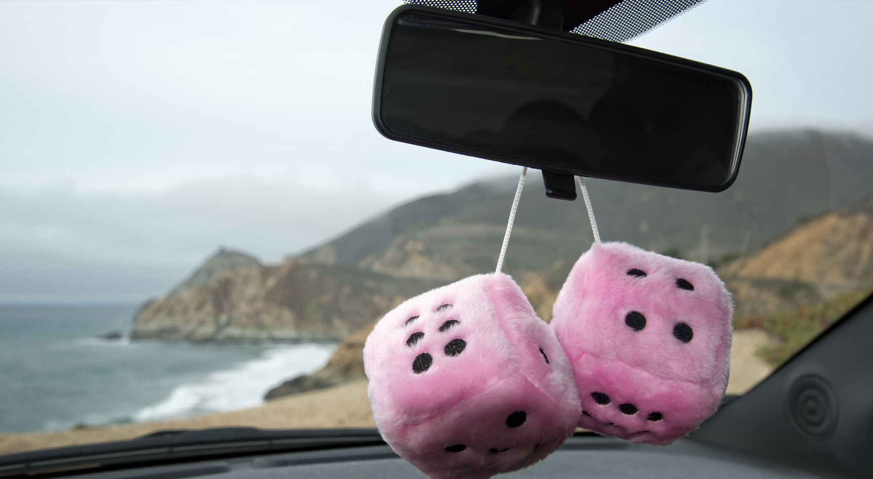 Fluffy dice hanging from the rear-vision mirror.
