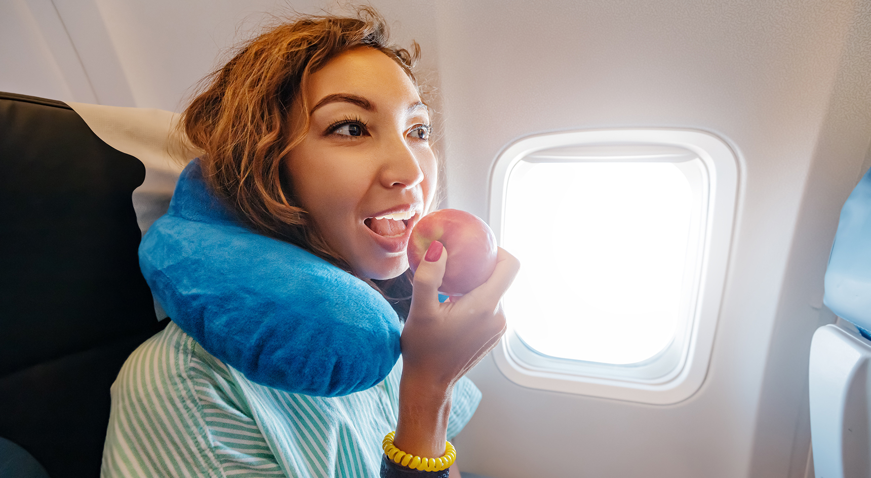 Woman eating an apple during a flight.
