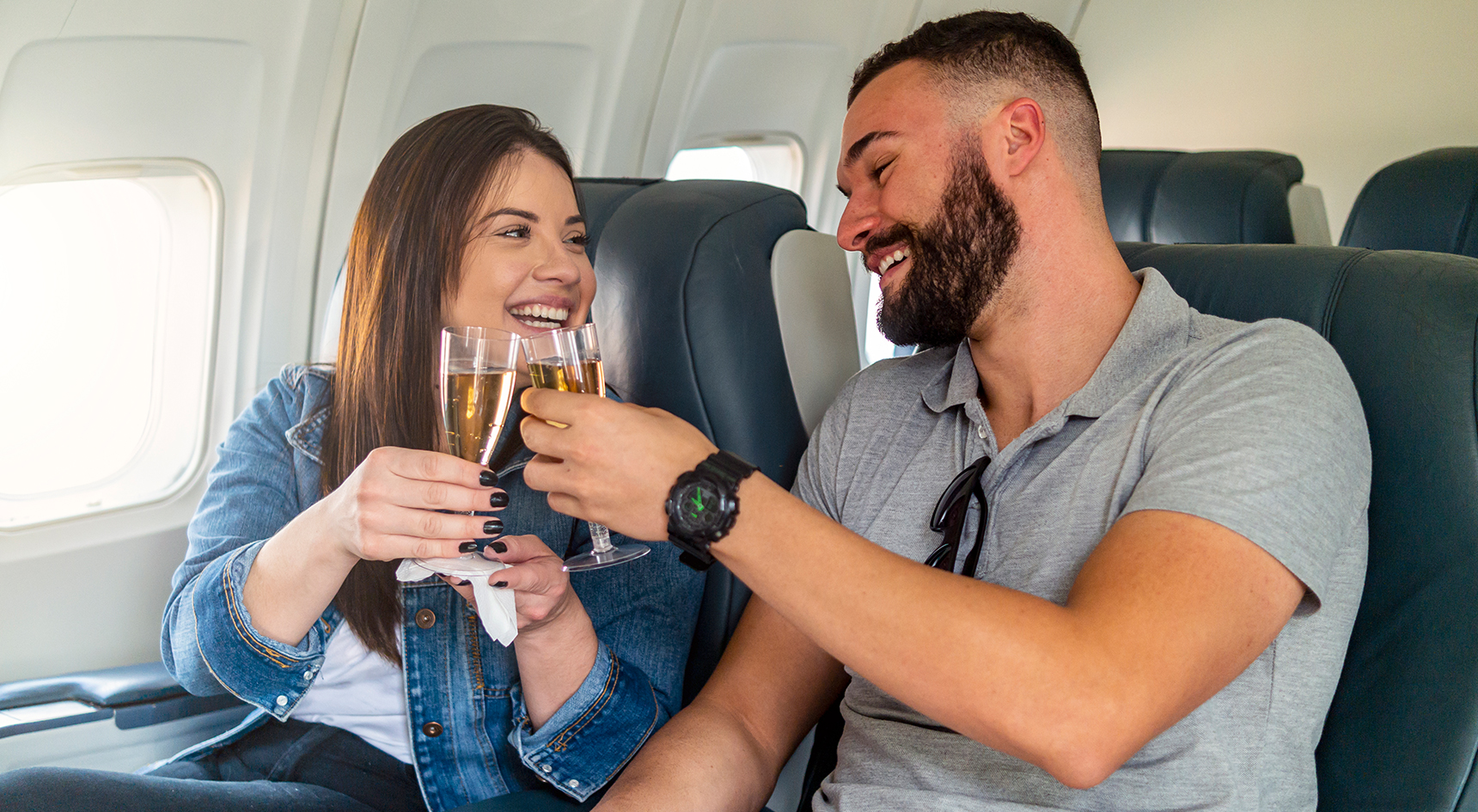Couple toasting with champagne on a plane