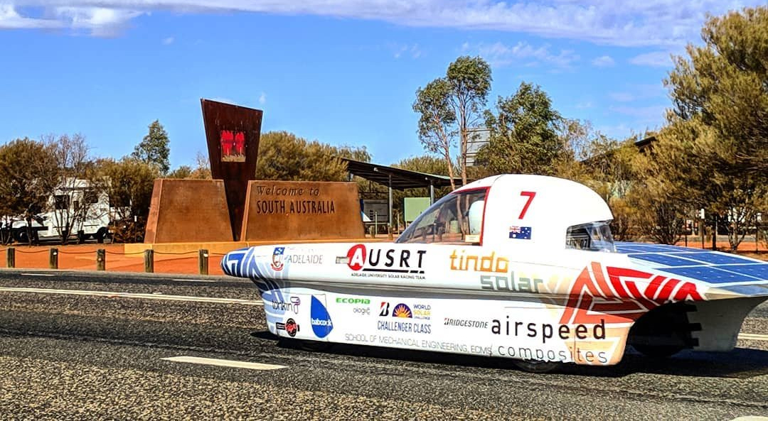 Solar car driving towards a sign that says Welcome to South Australia