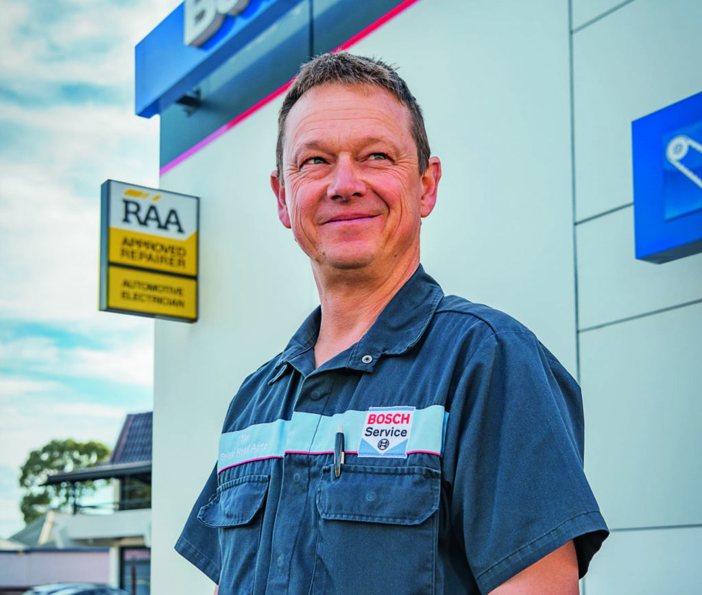 Belair Road Auto owner in front of RAA Approved Repairer sign