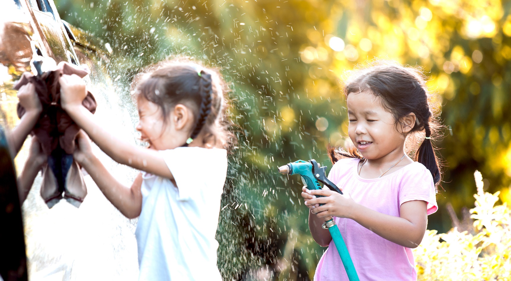 Two sisters helping to wash the car.