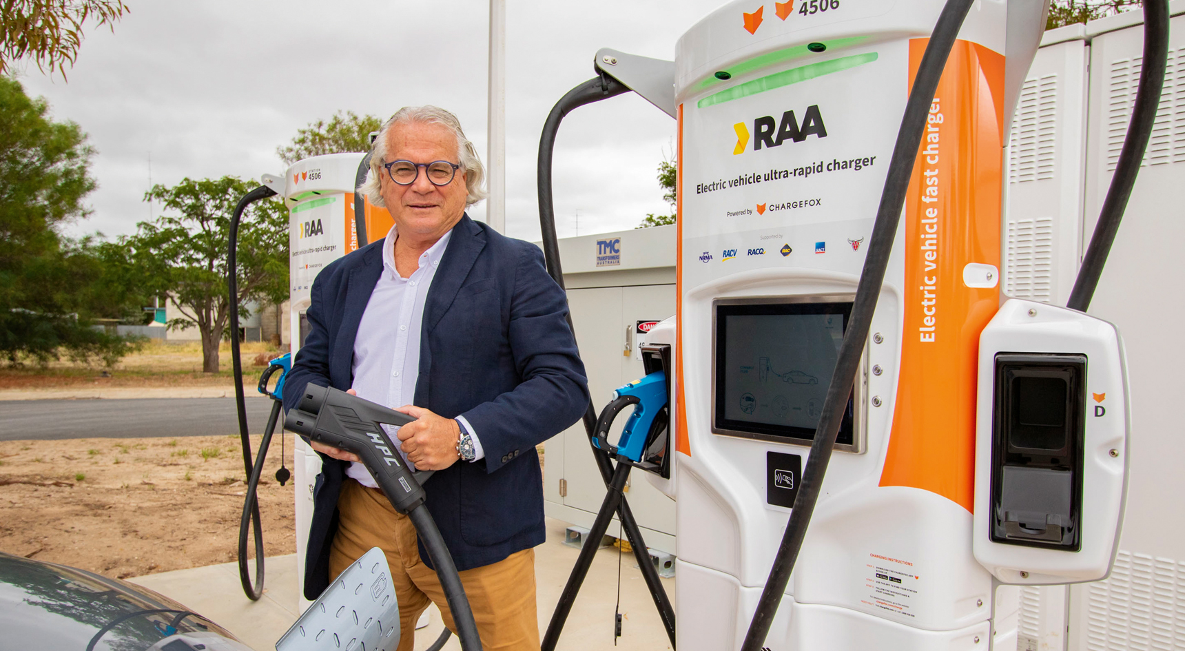 RAA's Mark Borlace holding a charger at the Chargefox station in Keith.
