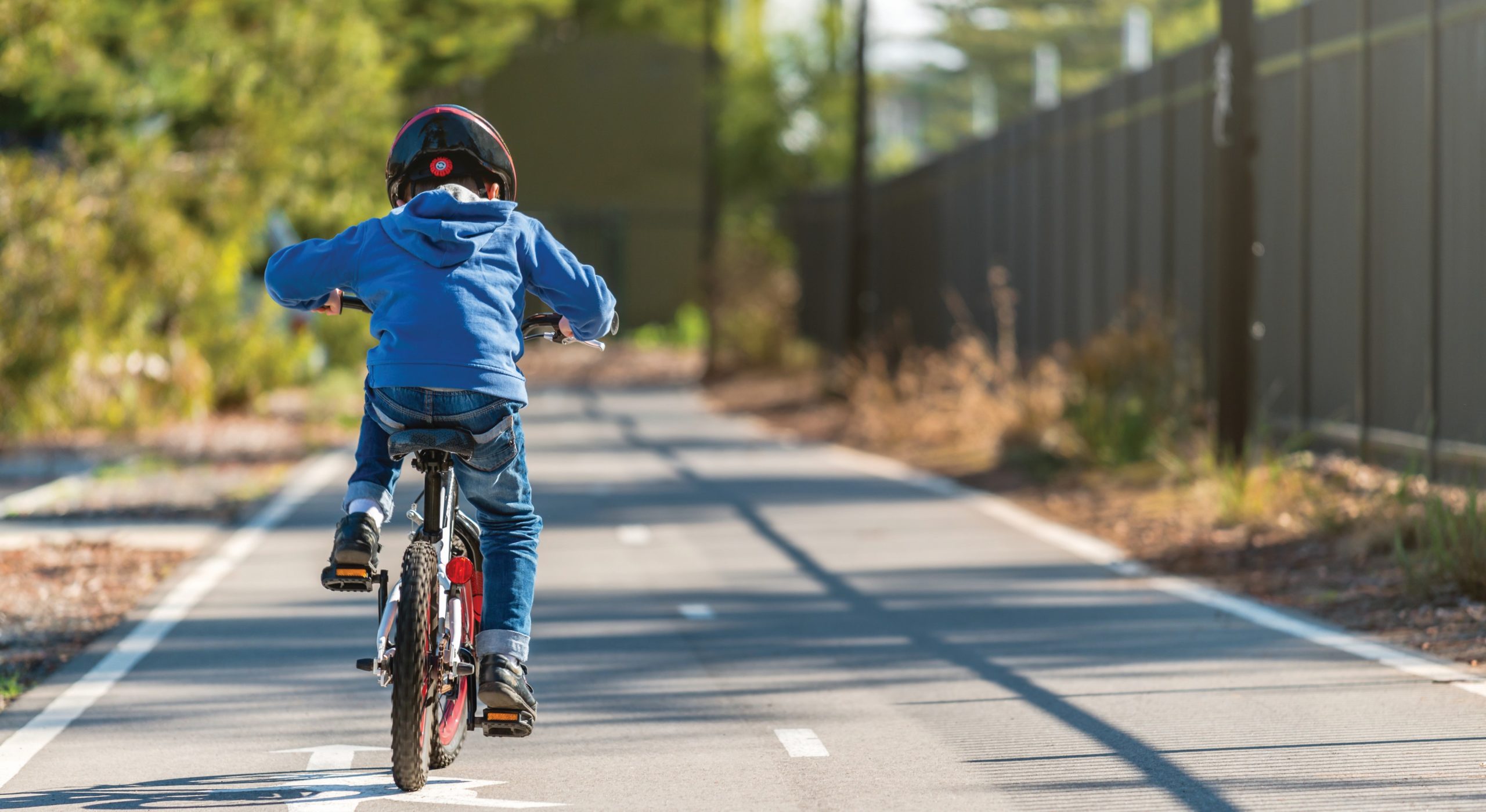 Young boy cycles safely on a dedicated bikeway.