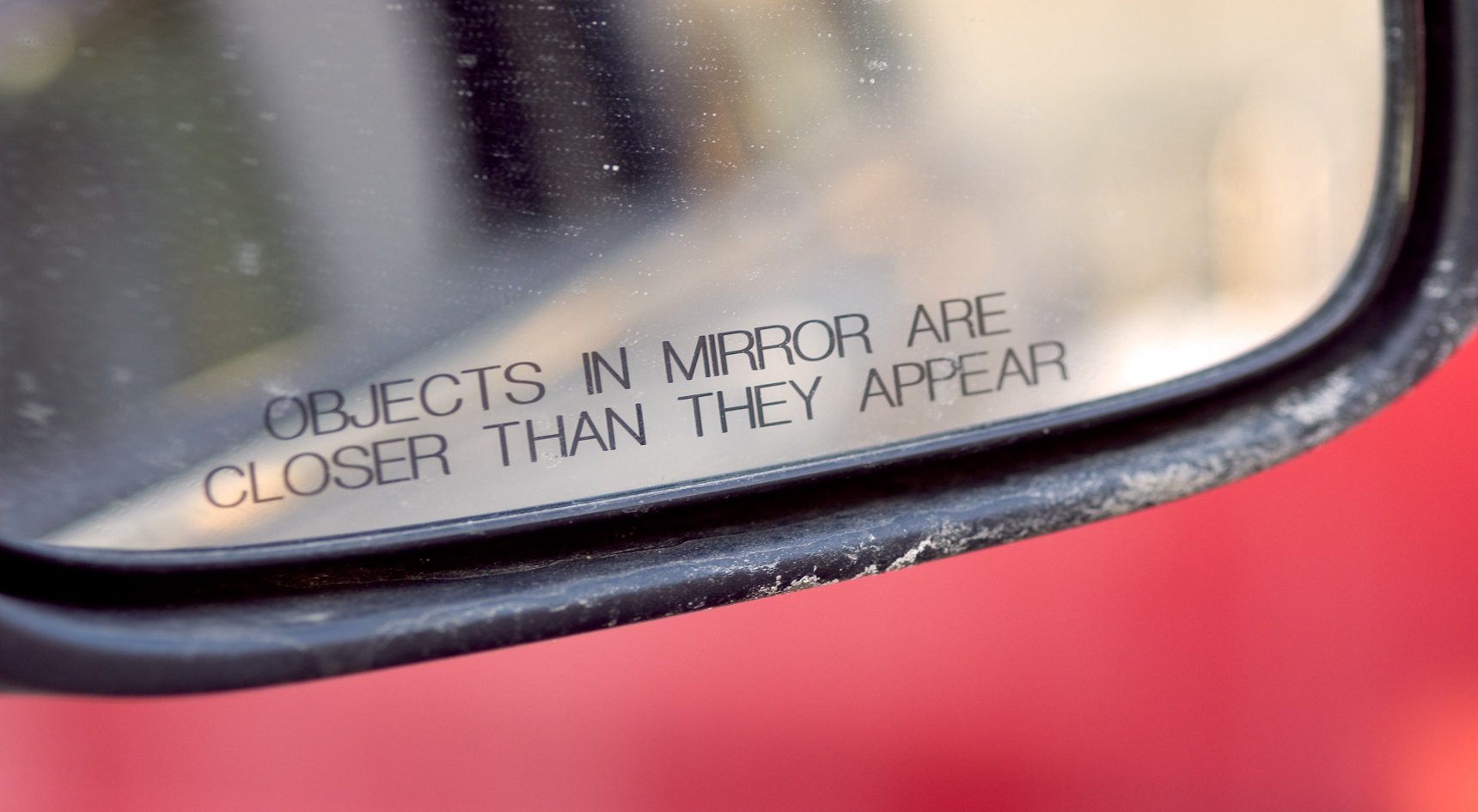 Close up of car's mirror with the words 'Objects in mirror are closer than they appear'