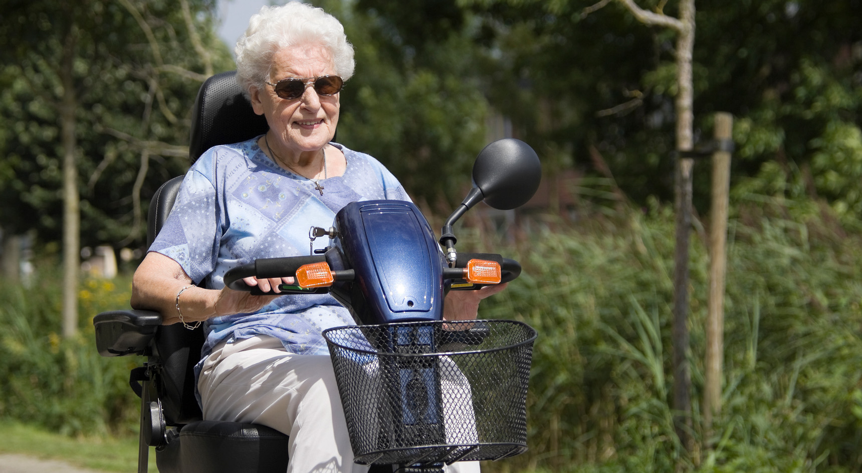 Elderly lady riding a motorised scooter.