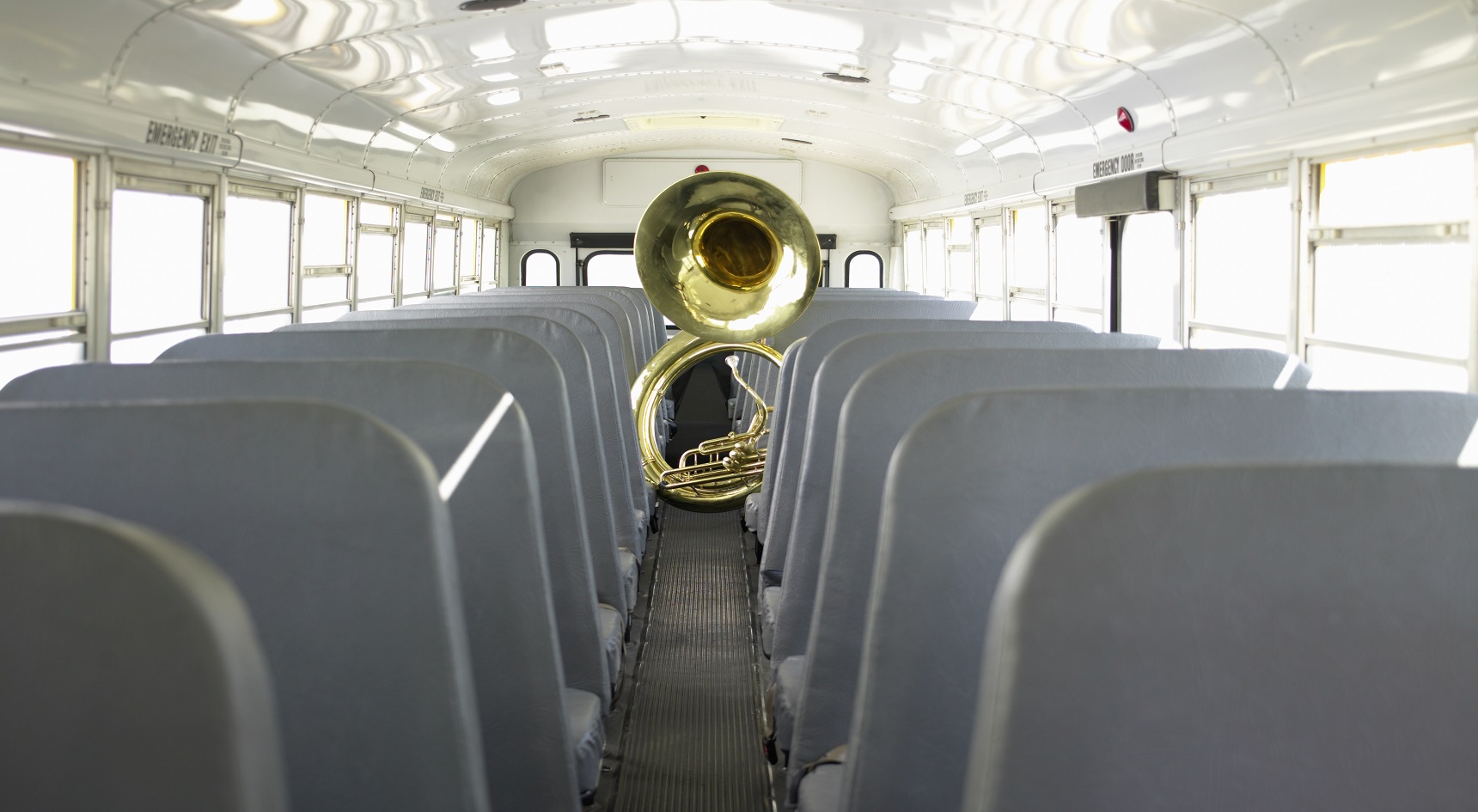 Musical instrument the tuba left on an empty bus.