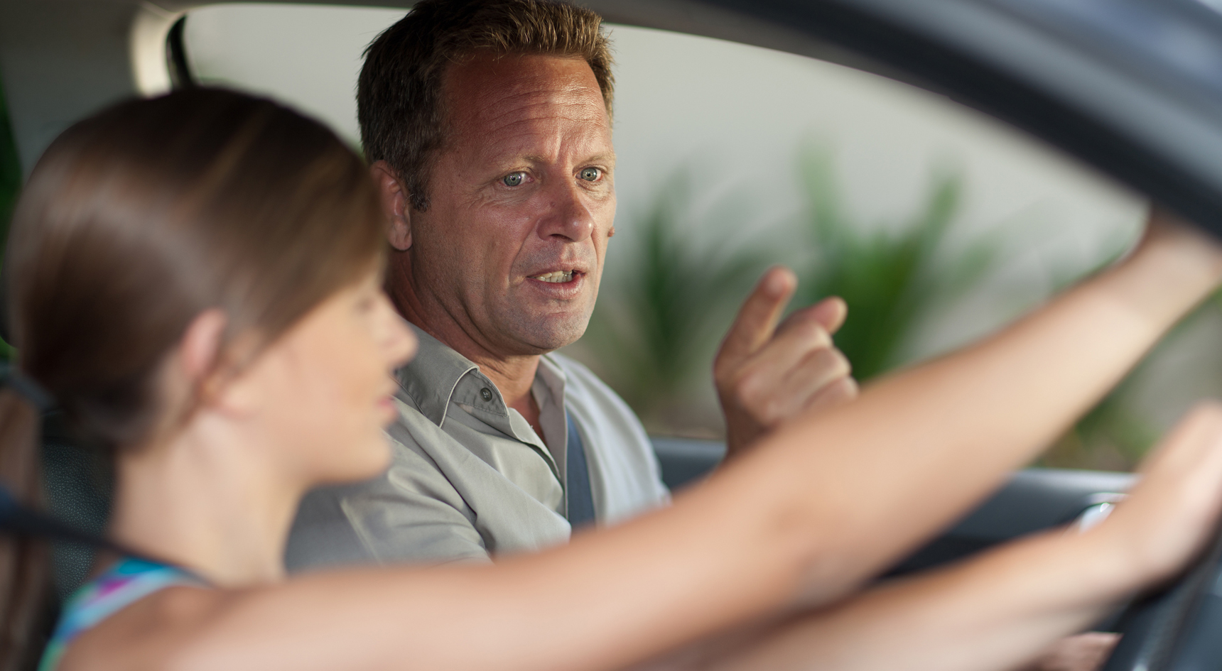 A father teaching his daughter how to drive.