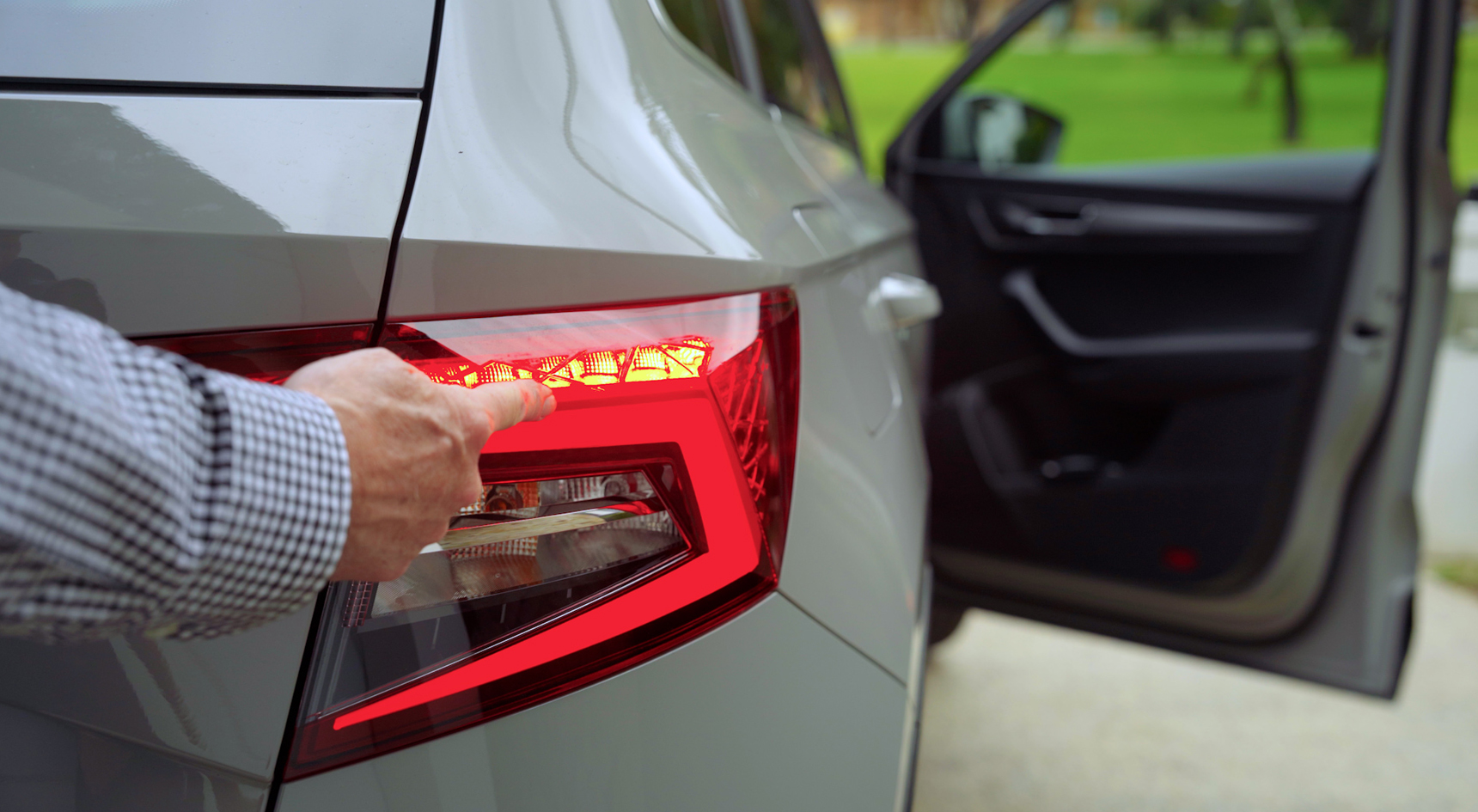 A close up of a person checking their taillights. 