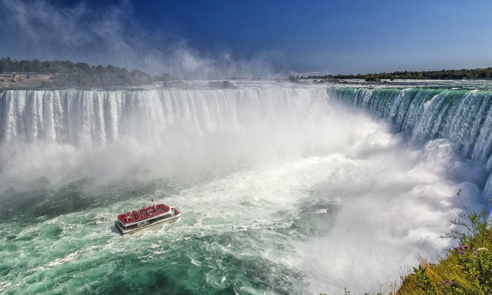 Niagara Falls with a small boat approaching.