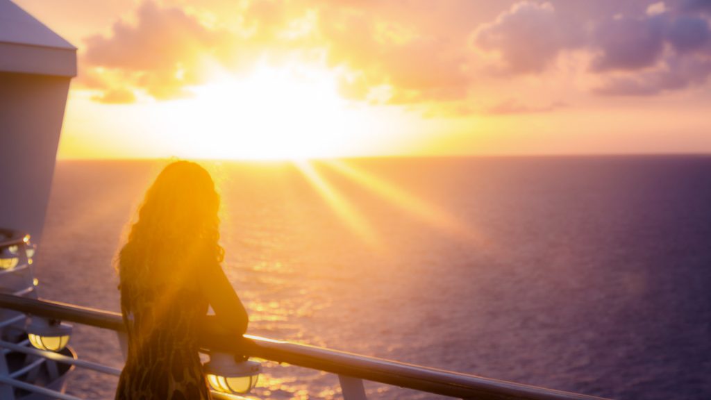 A person watching the sunset from a cruise.