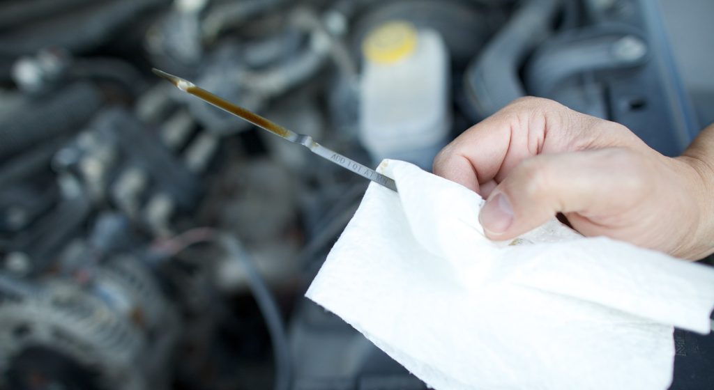 Checking oil level on a dipstick.