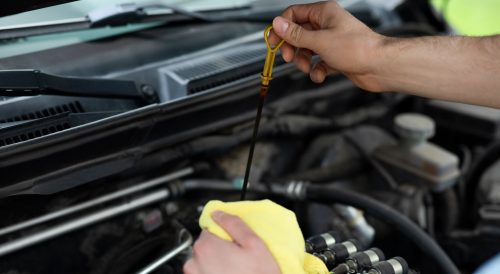 Checking engine oil with a dipstick.