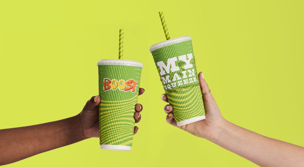 Two hands each holding a Boost Juice smoothie cup, one says "My main squeeze".